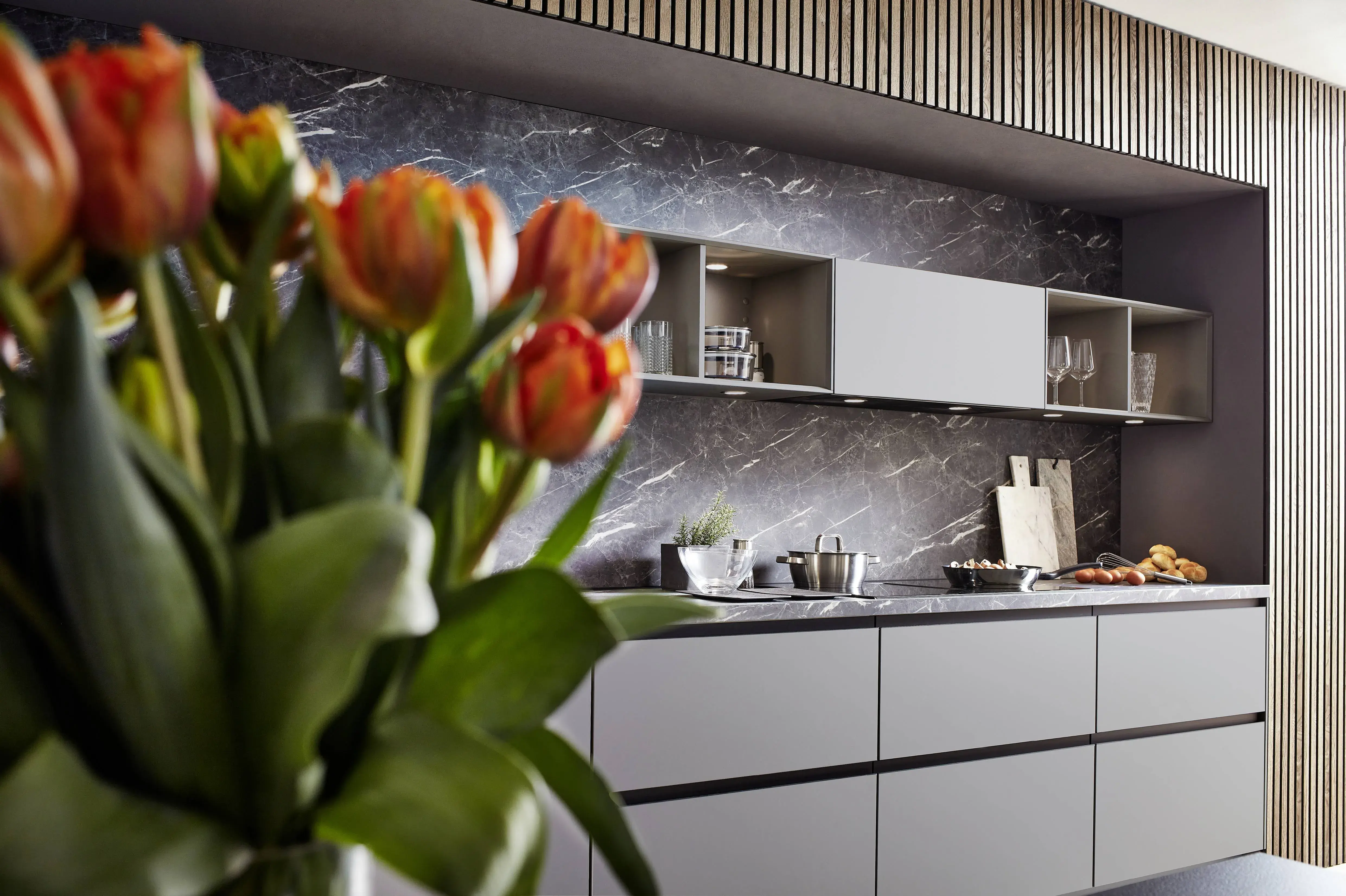 Nobilia Lichtgrau mit Marmordekor und mit roten Tulpen